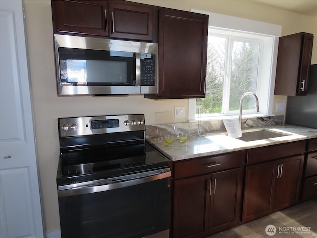 943 Silver King Ave SE, Ocean Shores, WA 98569 - kitchen featuring stainless steel microwave, range with electric cooktop, a sink, dark brown cabinets, and light stone countertops