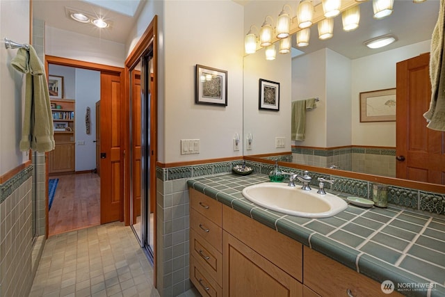 681 Smugglers Cove Rd, Friday Harbor, WA 98250 - full bath featuring a wainscoted wall, vanity, tile patterned floors, and tile walls