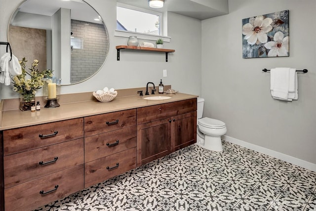 bathroom with baseboards, toilet, and vanity