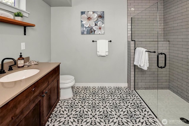 bathroom with toilet, vanity, baseboards, and a shower stall