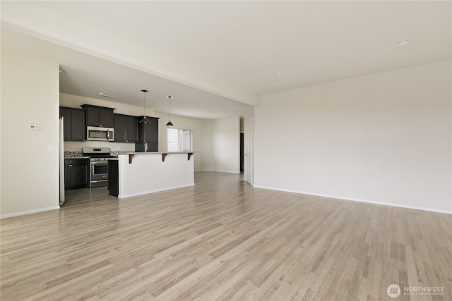 6733 Birdseye Ave NE, Lacey, WA 98516 - unfurnished living room featuring light wood-style floors and baseboards