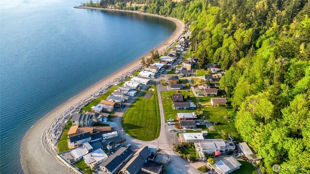 bird's eye view featuring a wooded view, a water view, and a residential view