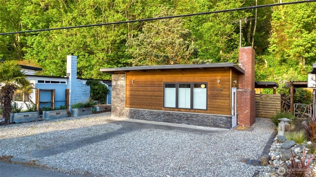exterior space with a chimney and stone siding