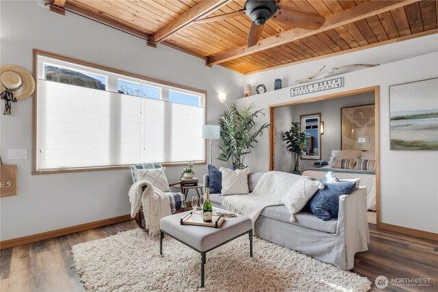 living area featuring wood finished floors, beamed ceiling, baseboards, wood ceiling, and a ceiling fan