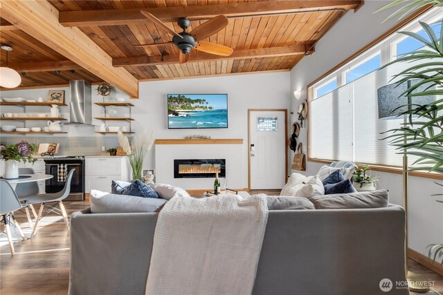 living area featuring a glass covered fireplace, wood ceiling, beam ceiling, and wood finished floors