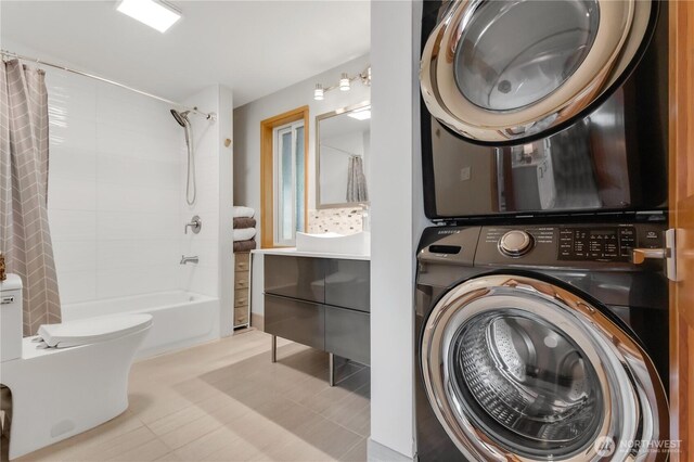 washroom with stacked washer and clothes dryer and laundry area