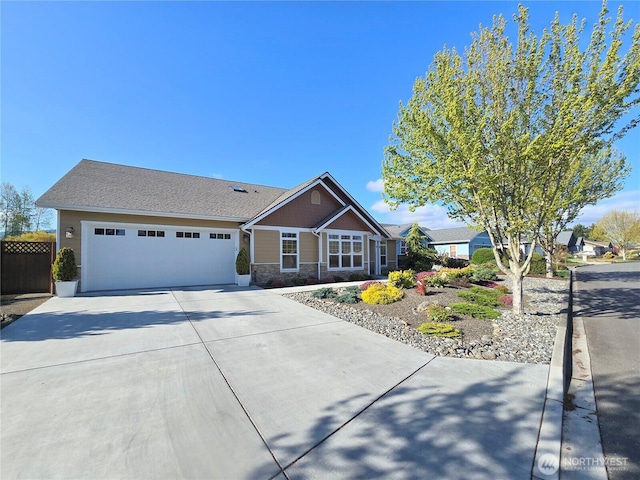 view of front facade with concrete driveway, an attached garage, and stone siding