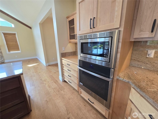 90 Broadmoor St, Sequim, WA 98382 - kitchen with appliances with stainless steel finishes, light brown cabinetry, lofted ceiling, light wood finished floors, and tasteful backsplash