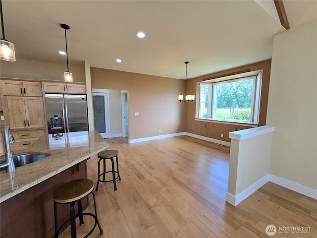 90 Broadmoor St, Sequim, WA 98382 - kitchen featuring stainless steel fridge, a sink, a kitchen breakfast bar, baseboards, and light stone countertops