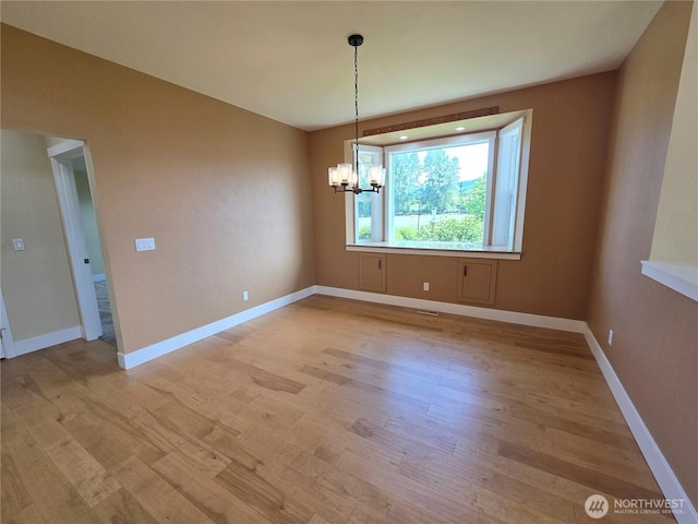 90 Broadmoor St, Sequim, WA 98382 - unfurnished dining area with a chandelier, light wood-style flooring, and baseboards