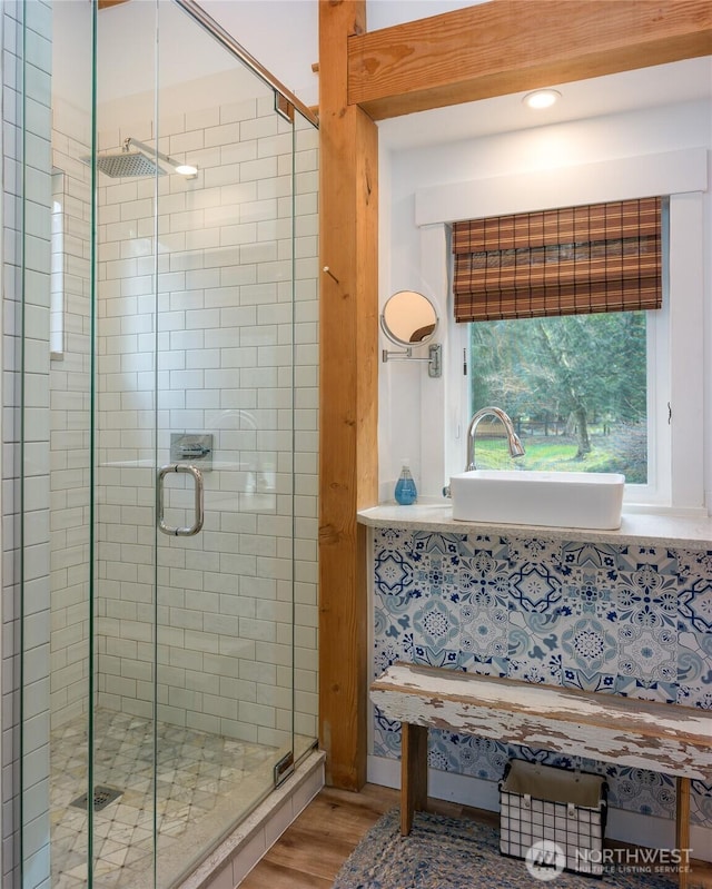 full bath featuring a stall shower, wood finished floors, and a sink