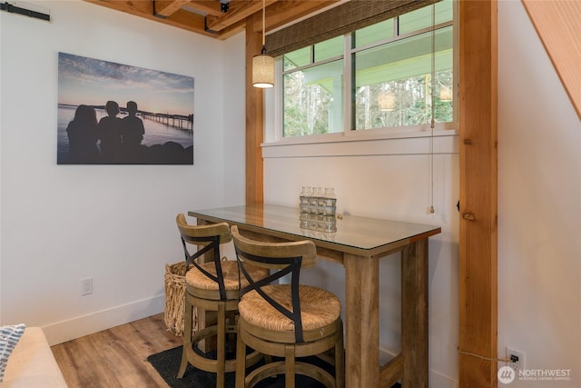 dining area with baseboards and wood finished floors