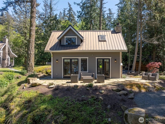 back of property featuring a standing seam roof, metal roof, french doors, a patio, and outdoor lounge area