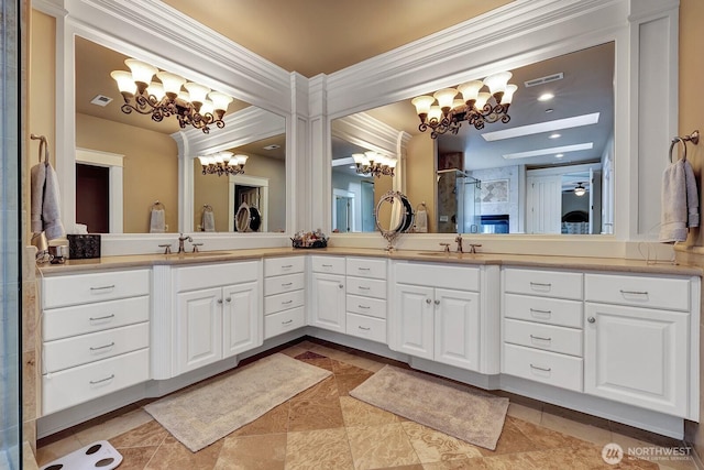 bathroom with a shower stall, a notable chandelier, vanity, ornamental molding, and visible vents