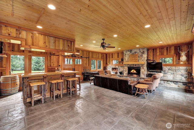 living area with wood ceiling, wood walls, recessed lighting, and plenty of natural light