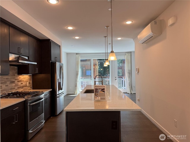 6528C 32nd Ave NE Unit 5.1, Seattle, WA 98115 - kitchen featuring stainless steel appliances, under cabinet range hood, an AC wall unit, decorative backsplash, and a kitchen island with sink
