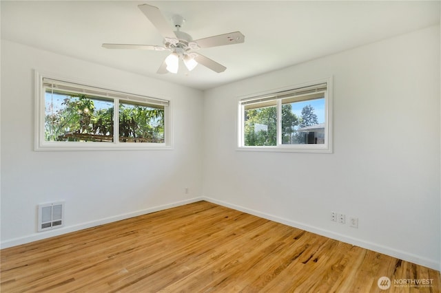 unfurnished room featuring light wood finished floors, baseboards, visible vents, and a healthy amount of sunlight