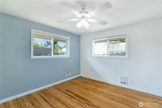 empty room featuring visible vents, baseboards, light wood-style floors, and ceiling fan