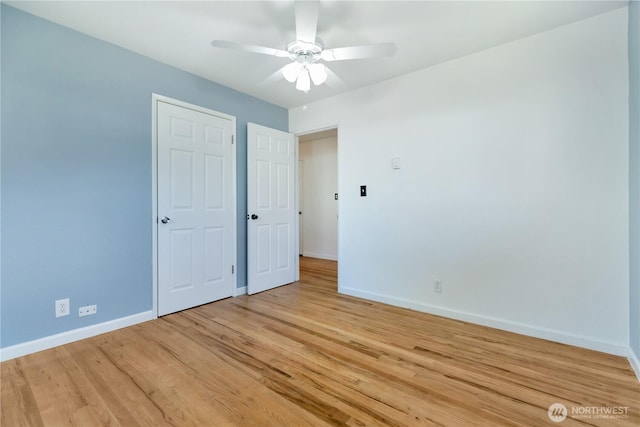 unfurnished bedroom featuring ceiling fan, baseboards, and light wood-style flooring