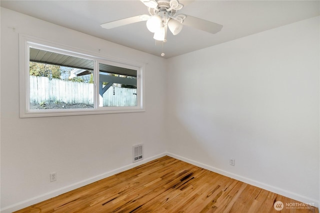 empty room featuring light wood-style flooring, visible vents, a ceiling fan, and baseboards