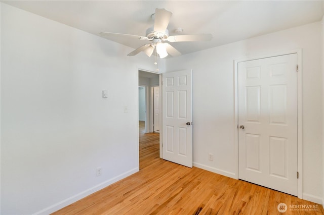 unfurnished bedroom with ceiling fan, baseboards, and light wood-type flooring