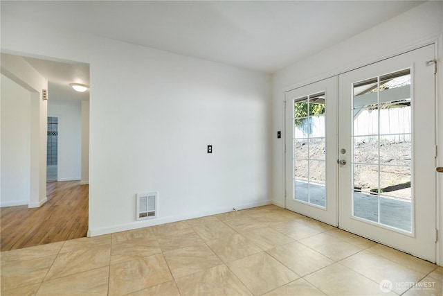 interior space with visible vents, baseboards, and french doors