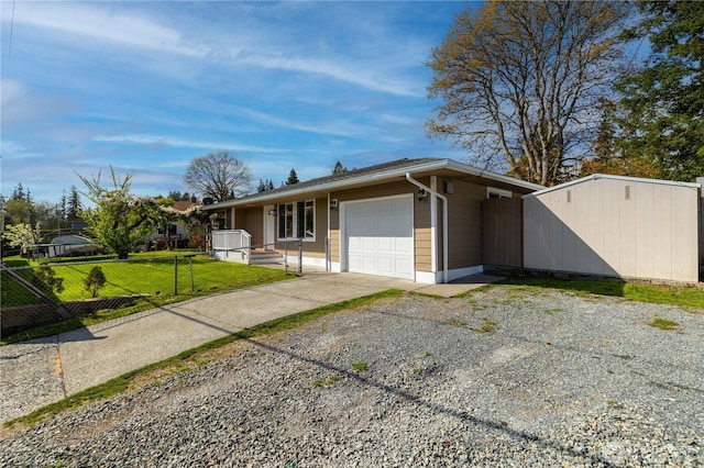 view of front of property featuring gravel driveway, a garage, a front yard, and fence private yard