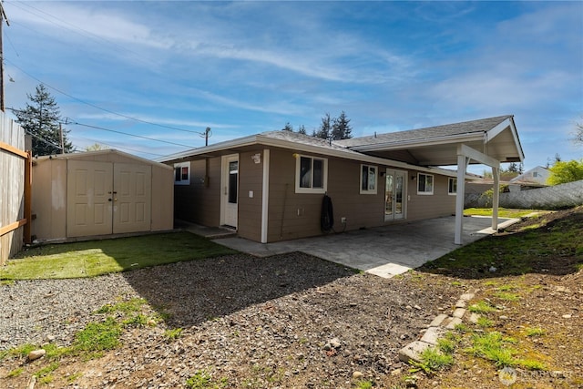 back of property with a storage unit, an outbuilding, a patio, and fence
