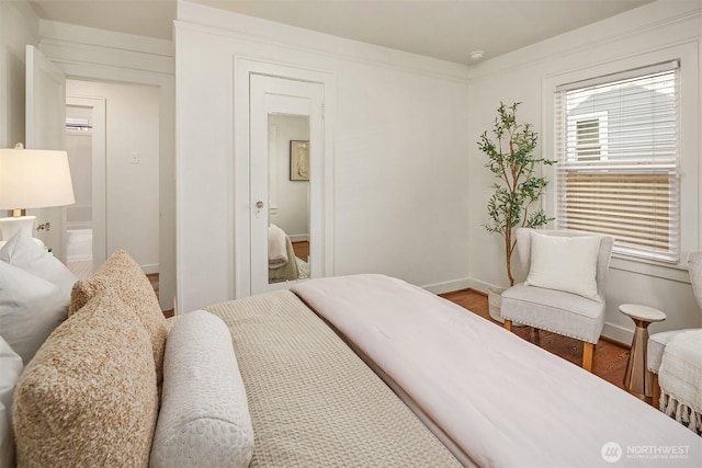 bedroom featuring baseboards and wood finished floors