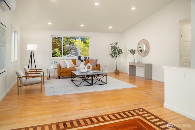 living area with an AC wall unit, baseboards, recessed lighting, and wood finished floors