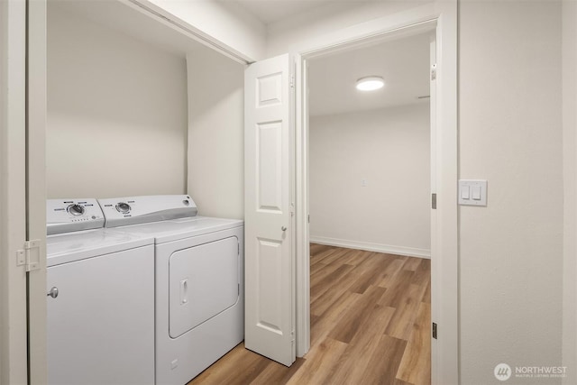 washroom featuring light wood-type flooring, laundry area, and washer and dryer