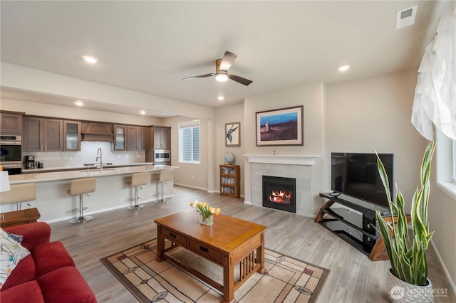26334 203rd Pl SE, Covington, WA 98042 - living room featuring light wood finished floors, recessed lighting, ceiling fan, and a tile fireplace