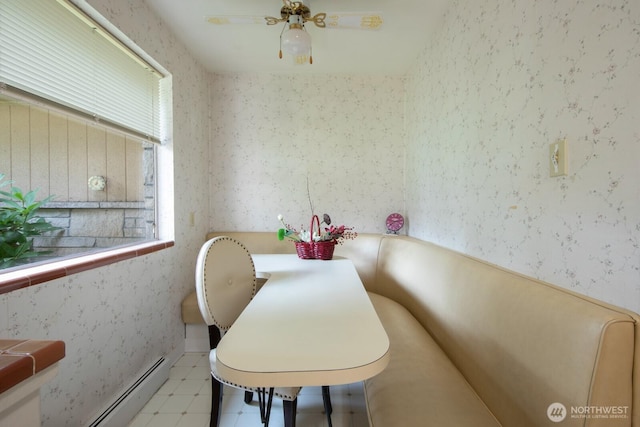 dining area with tile patterned floors, a ceiling fan, baseboard heating, and wallpapered walls