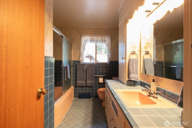 full bath with vanity, tile patterned flooring, a wainscoted wall, tile walls, and wallpapered walls