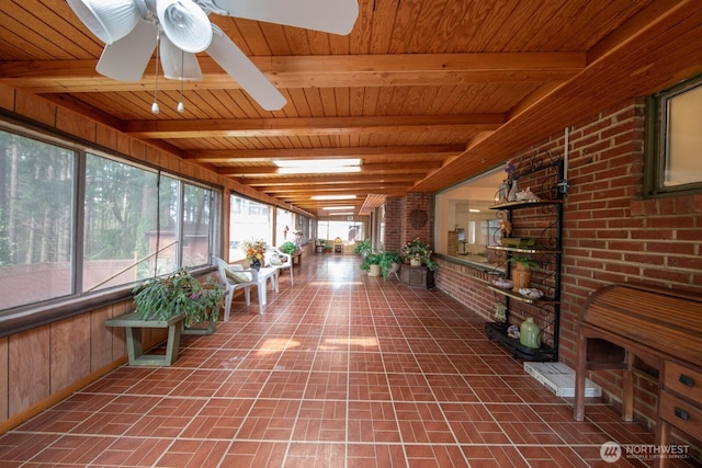 unfurnished sunroom featuring beamed ceiling