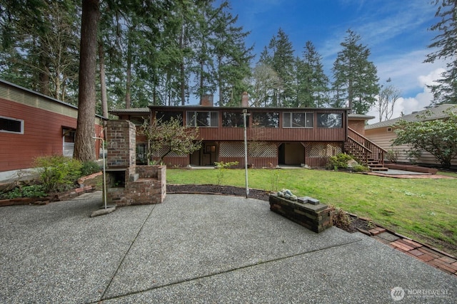 back of house with a sunroom, a yard, a chimney, a patio, and stairs