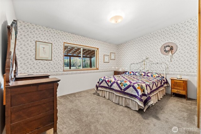 bedroom featuring wallpapered walls and carpet