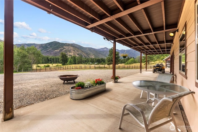 view of patio with a mountain view, fence, and a rural view