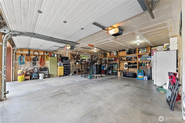 garage featuring freestanding refrigerator and a garage door opener