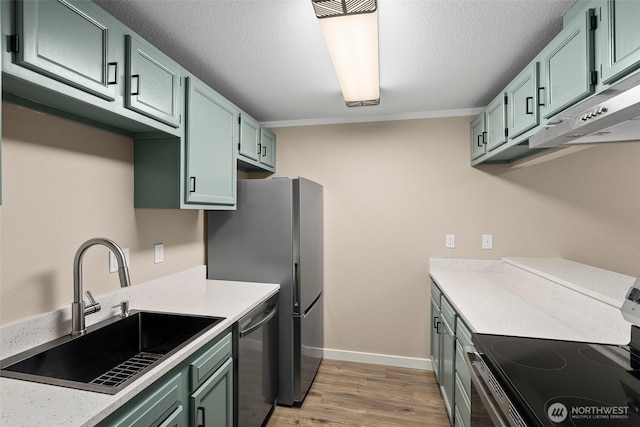 1700 Lake Park Dr SW Unit 8, Tumwater, WA 98512 - kitchen with light countertops, stainless steel appliances, a textured ceiling, a sink, and light wood-style flooring