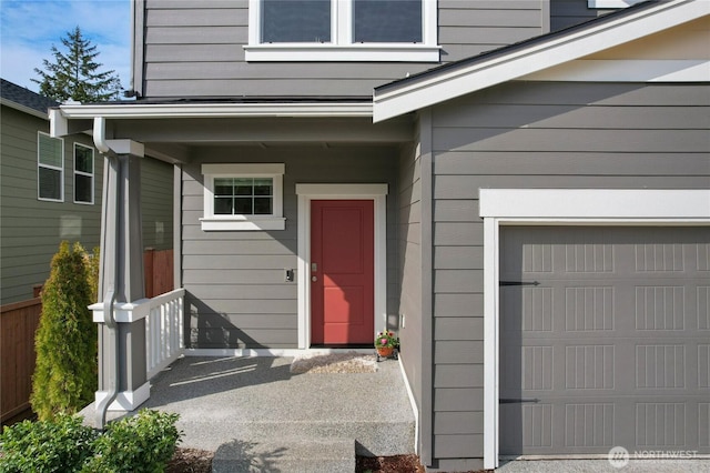 view of exterior entry featuring a garage and a porch