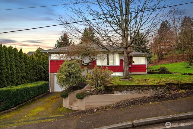 view of front of home with a front yard, a garage, and aphalt driveway