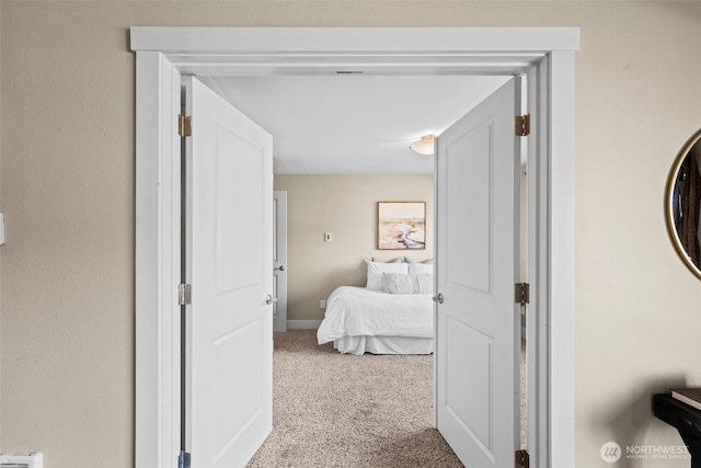 hallway featuring baseboards and carpet floors