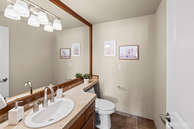 bathroom with toilet, vanity, and tile patterned flooring
