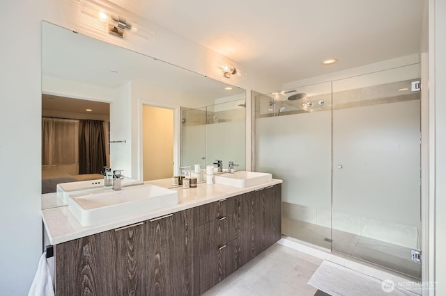 full bath featuring a shower stall, recessed lighting, double vanity, and a sink
