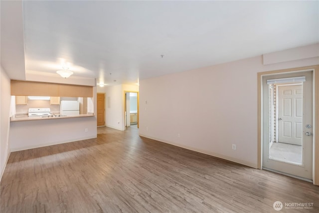 10240 Bridgeport Way SW, Lakewood, WA 98499 - unfurnished living room with baseboards, wood finished floors, and a sink