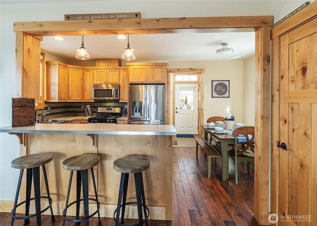 540 Porcupine Ln, Chelan, WA 98816 - kitchen with a sink, stainless steel appliances, backsplash, a peninsula, and dark wood-type flooring