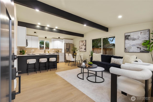 living area with recessed lighting, light wood-type flooring, and beam ceiling
