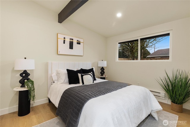 bedroom featuring baseboards, lofted ceiling with beams, a baseboard radiator, and wood finished floors