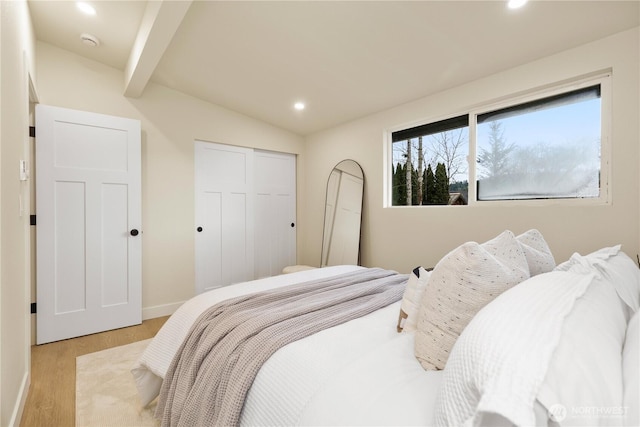bedroom featuring a closet, vaulted ceiling with beams, light wood-style flooring, baseboards, and recessed lighting